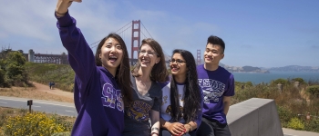 Four students taking a selfie by Golden Gate Bridge.